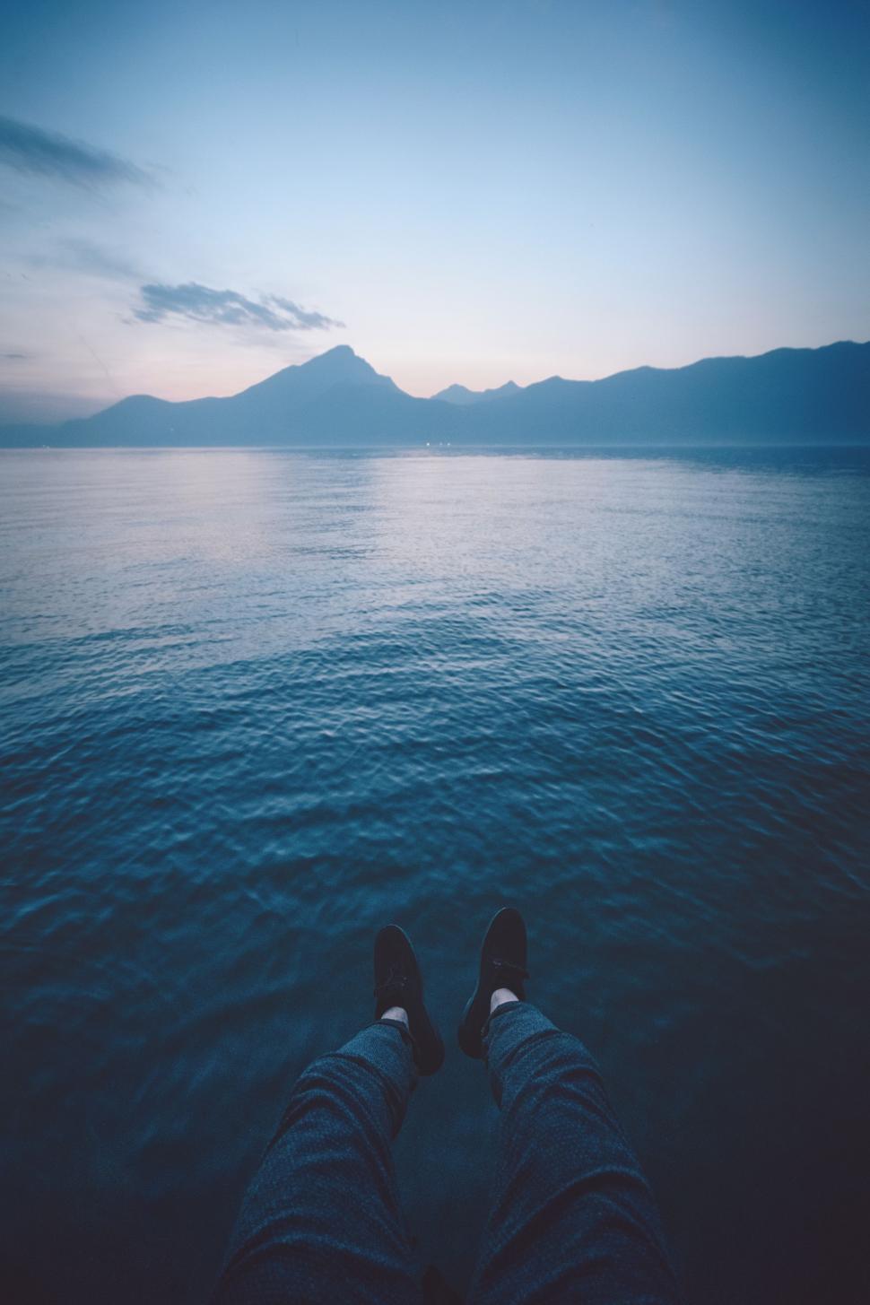Free Image of Persons Feet in Water With Mountains in Background 