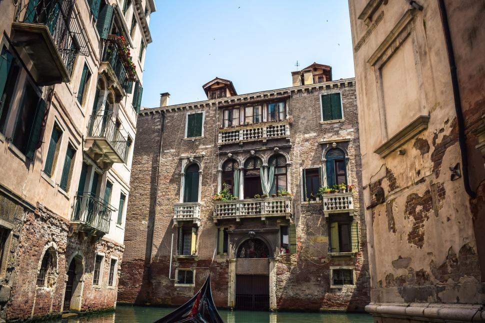 Free Image of Gondola Floating in Canal Between Two Buildings 