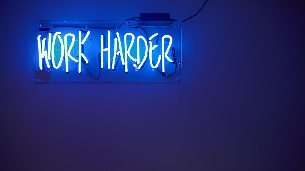 Free Image of Blue Neon Sign That Says Work Harder 