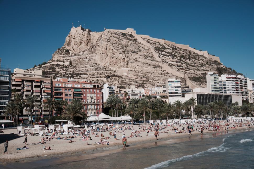 Free Image of Busy Beach With Mountain Background 