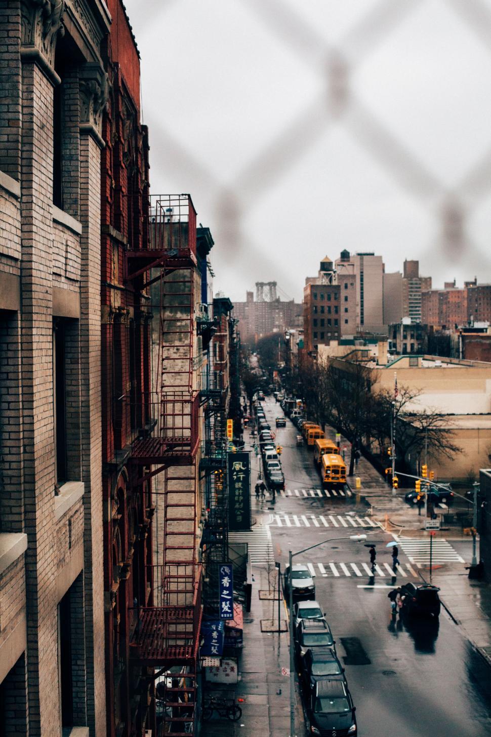 Free Image of City Street View Through Chain Link Fence 
