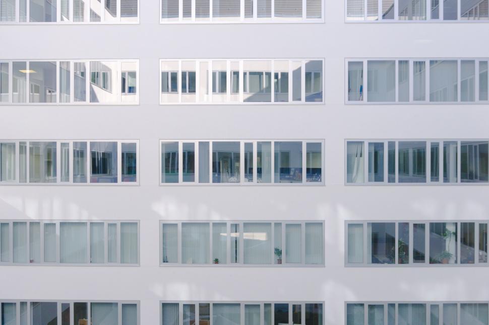 Free Image of Tall White Building With Lots of Windows 