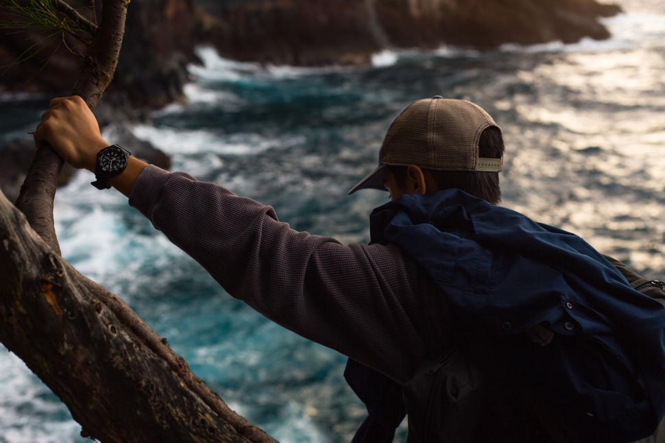 Free Image of Man Standing With Backpack on Cliff by Ocean 