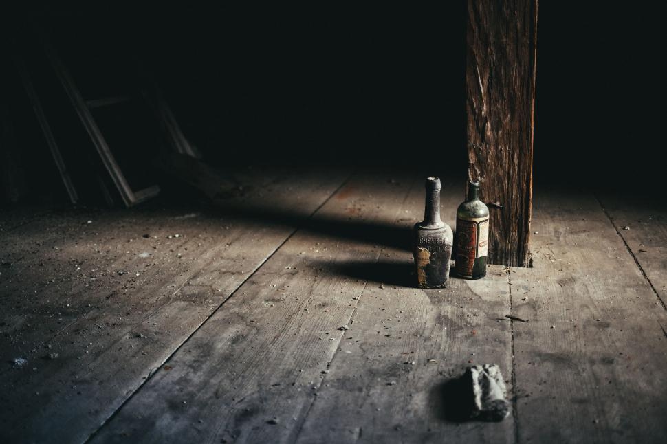 Free Image of Two Bottles Resting on Wooden Floor 