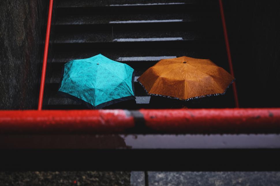 Free Image of Two Open Umbrellas on Red Rail 