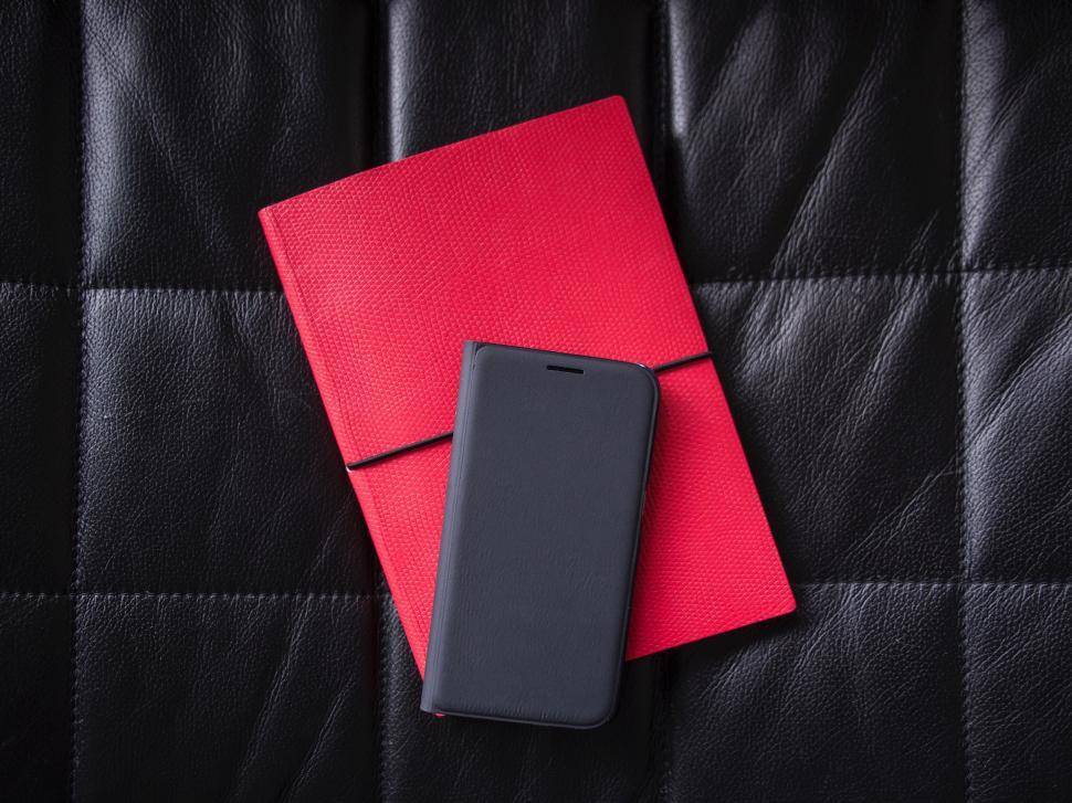 Free Image of Cell Phone on Top of Red Book 
