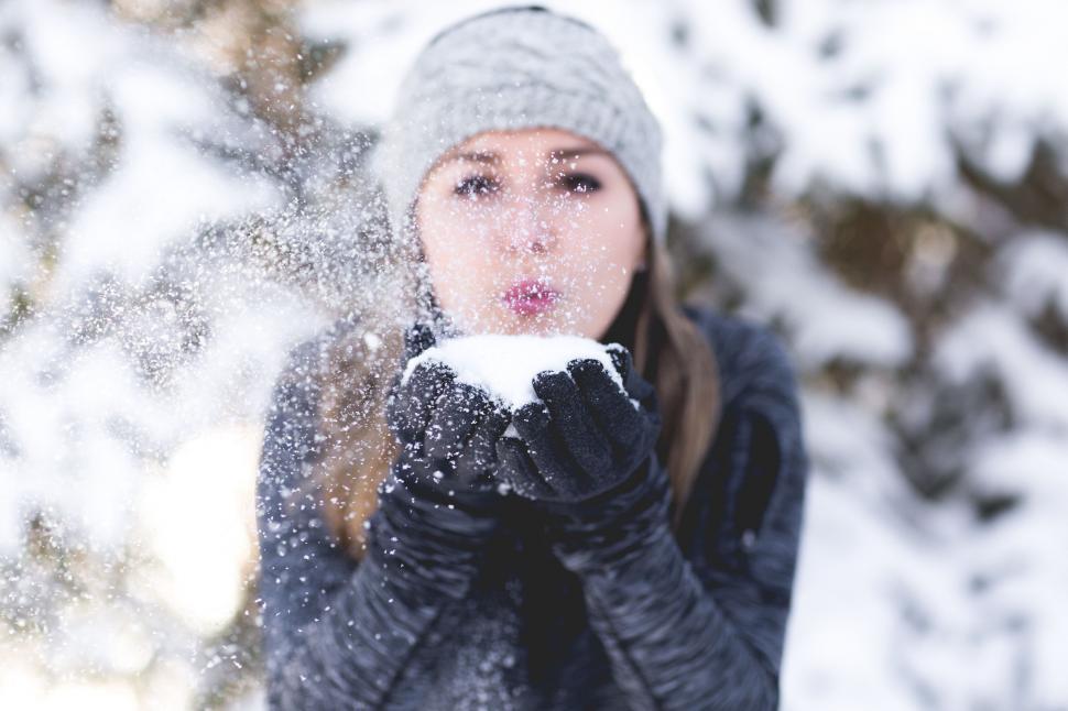 Free Image of Woman Blowing Snow in Front of Her Face 