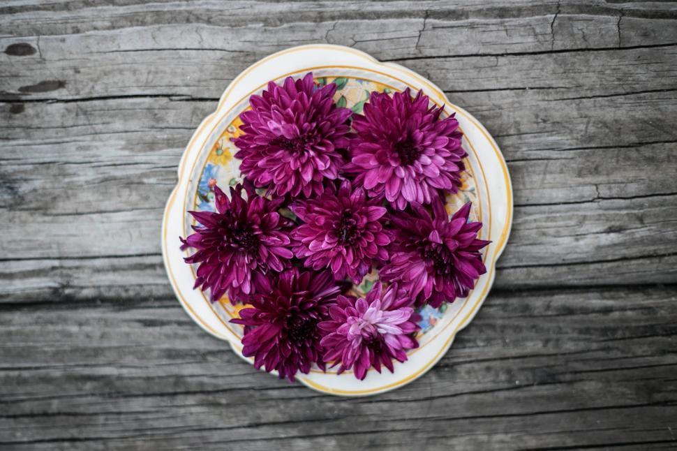 Free Image of Bowl of Purple Flowers on Wooden Table 