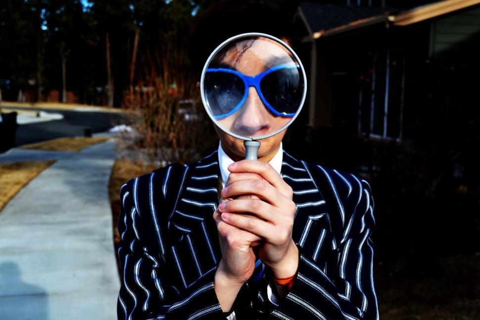 Free Image of Man Examining Face With Magnifying Glass 