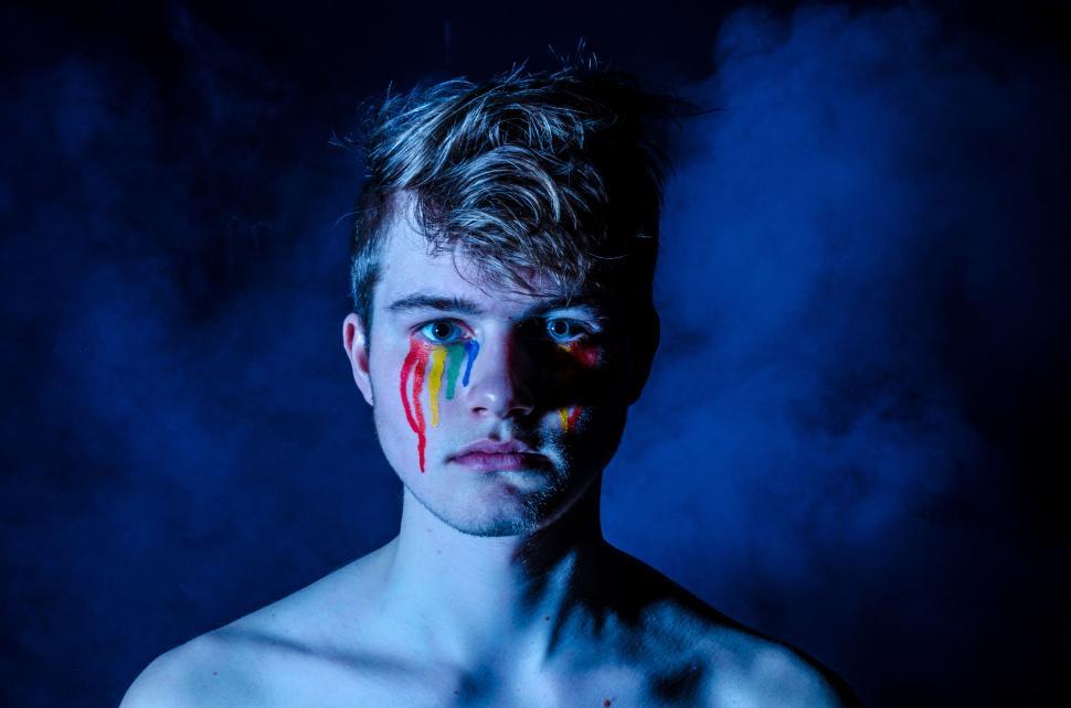 Free Image of Shirtless Man With Painted Face in the Dark 