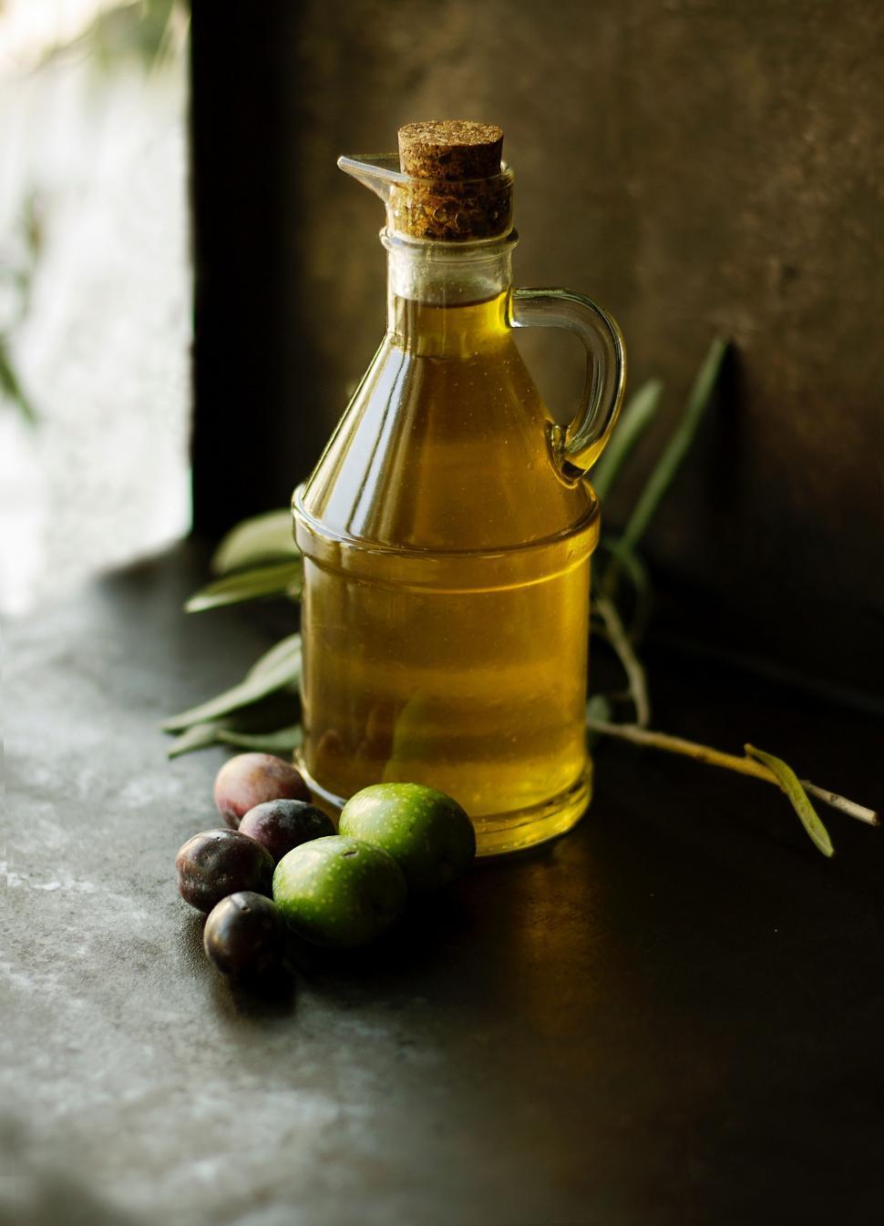 Free Image of Bottle of Olive Oil Next to Olives 