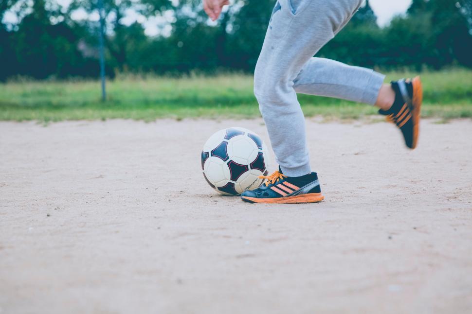 Free Image of Person Kicking Soccer Ball on Field 