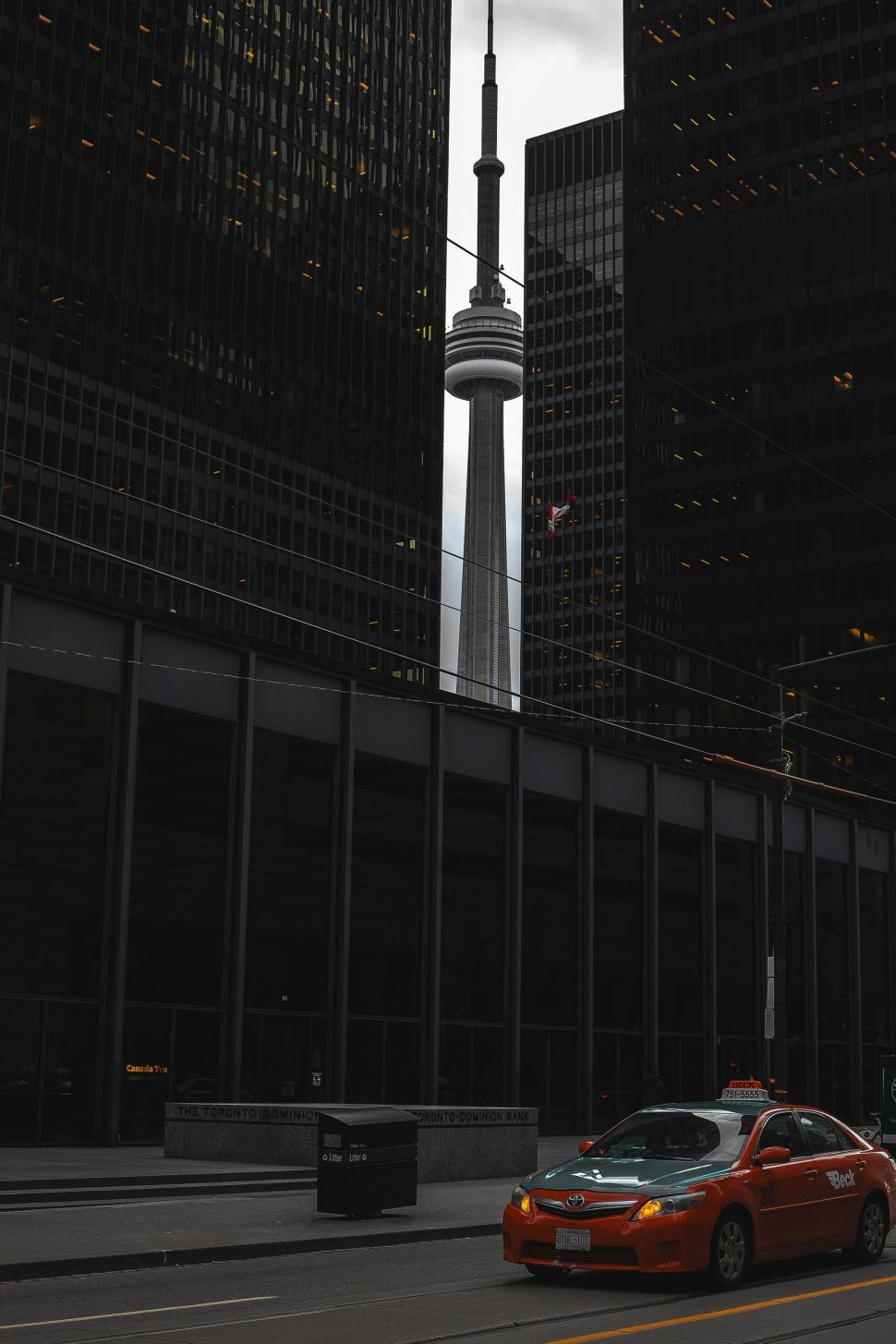 Free Image of Car Driving Down City Street With Tall Buildings 