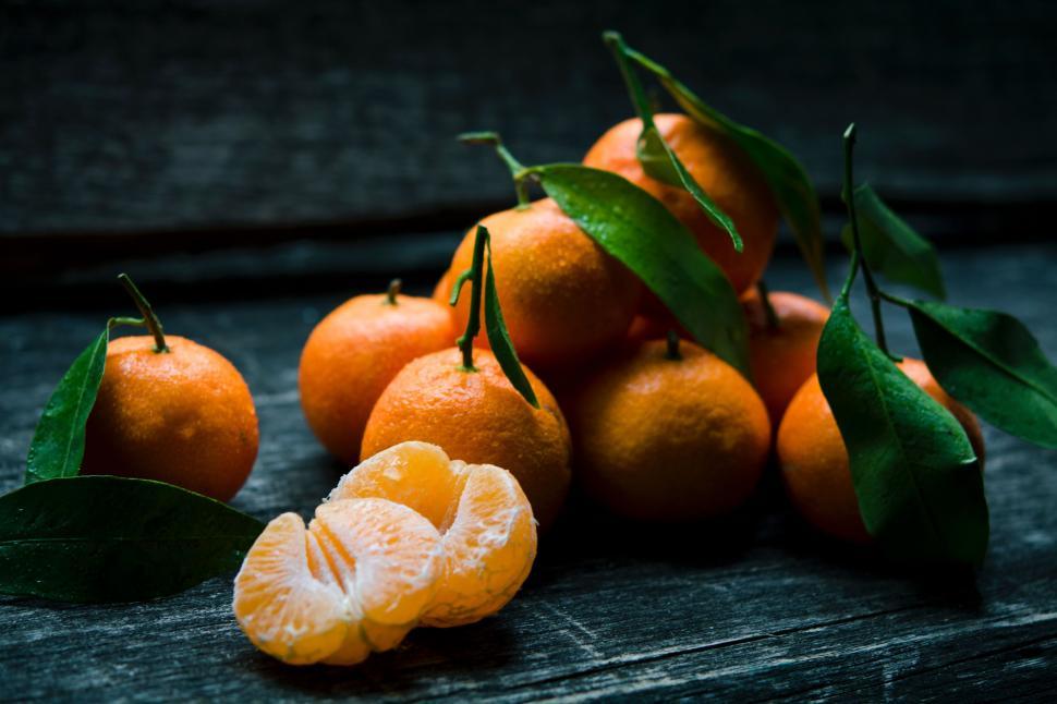 Free Image of A Pile of Oranges on a Wooden Table 