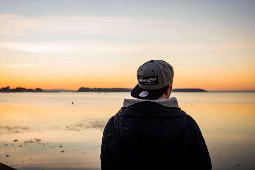 Free Image of Person Wearing Hat Looking Out Over Body of Water 