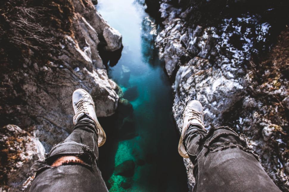 Free Image of Person Standing on Cliff Next to Water 