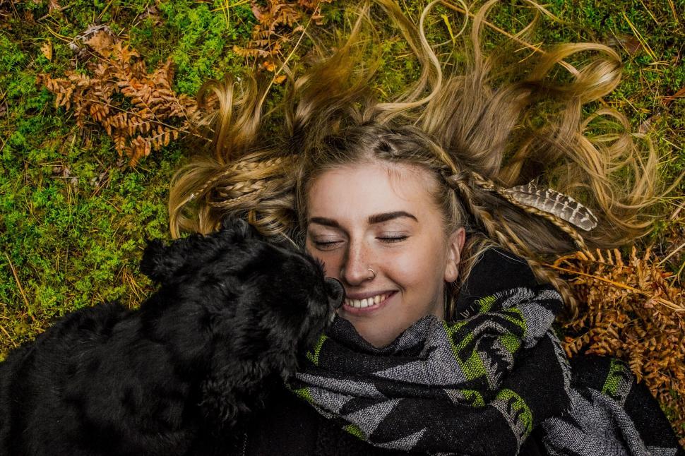 Free Image of Woman Laying in Grass With Dog 