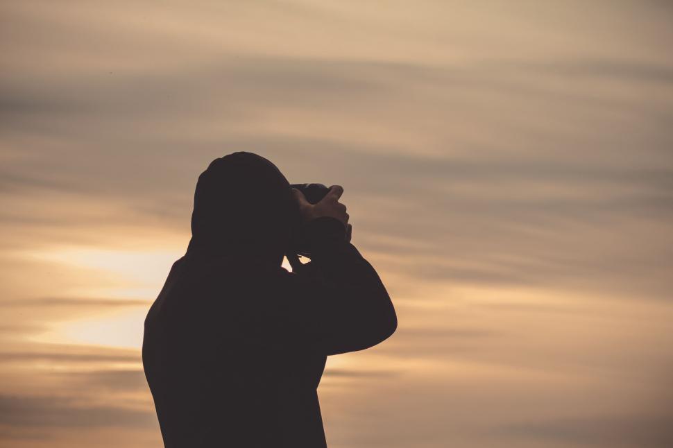 Free Image of Silhouette of Person Looking Through Binoculars 