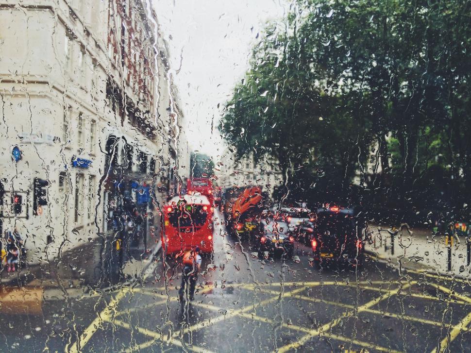 Free Image of Man Riding Bike Down Rain-Soaked Street 