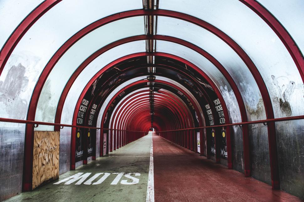 Free Image of Extended Tunnel With Red Floor and White Walls 