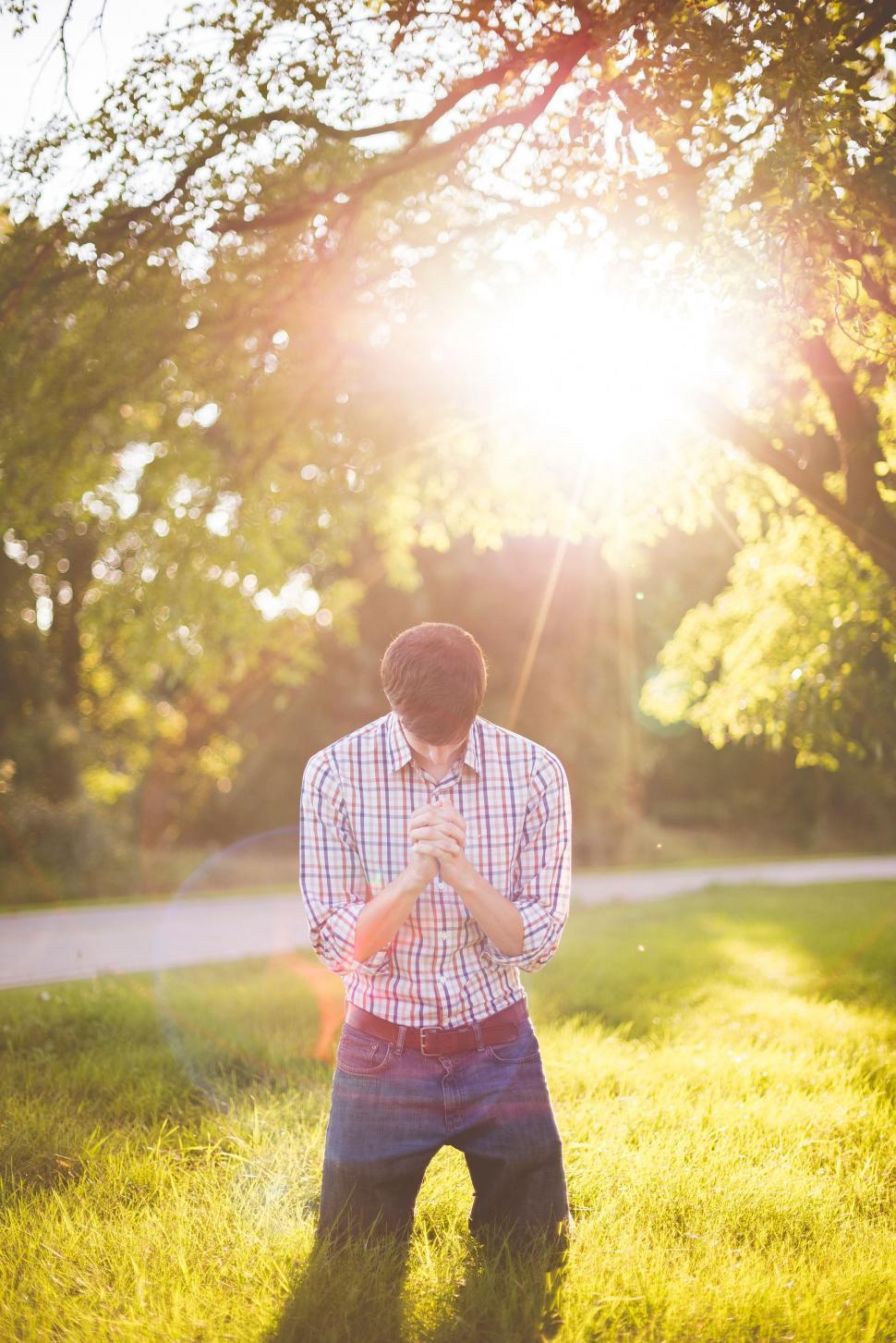 Free Image of Man Standing in Field With Hands Together 