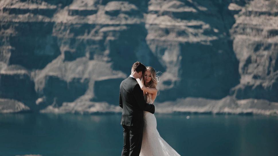 Free Image of Bride and Groom Standing in Front of Mountain Lake 