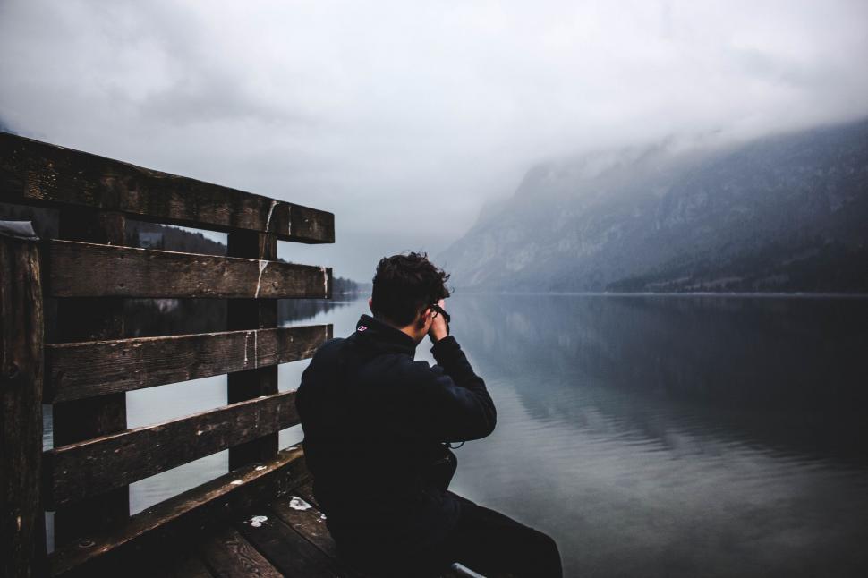 Free Image of Person Sitting on Bench by Water 
