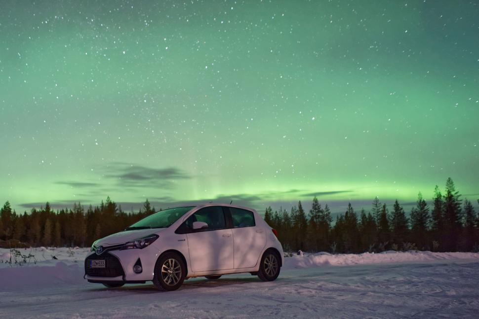 Free Image of White Car Parked in Snow Under Green Light 