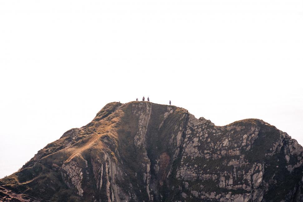 Free Image of Group of People Standing on Top of a Mountain 
