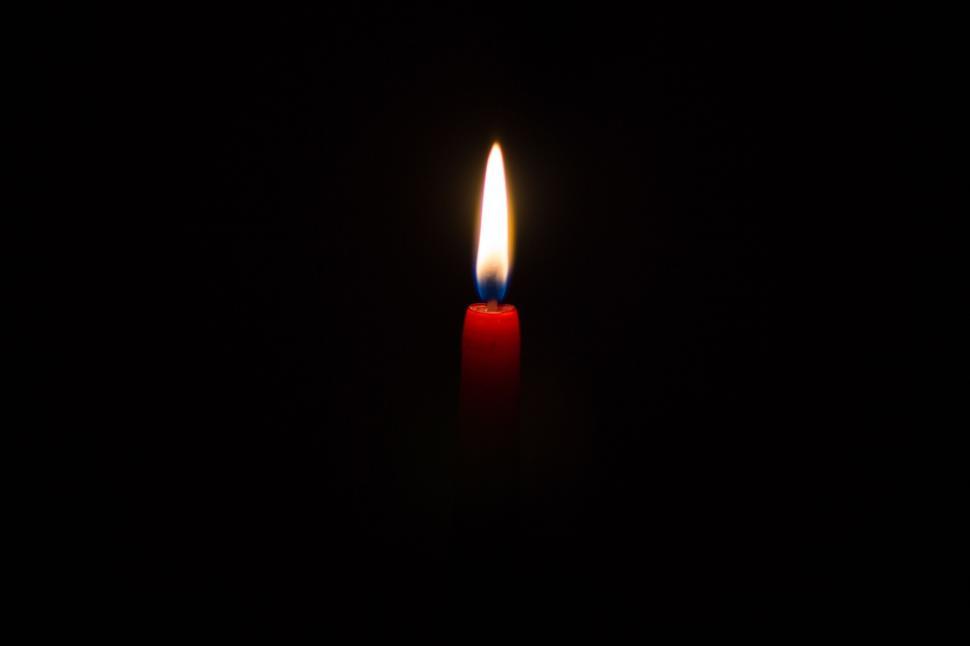 Free Image of A Single Candle Illuminated in Darkness 