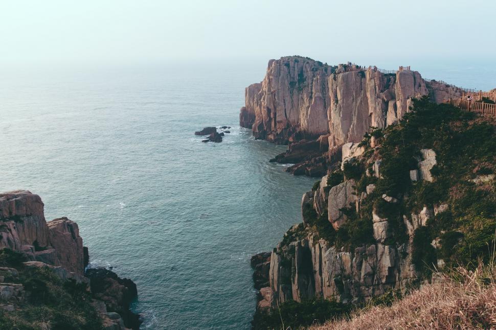 Free Image of Rocky Cliff Next to Large Body of Water 