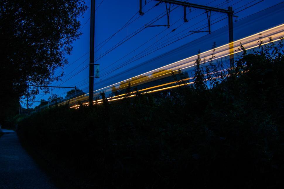 Free Image of A Train Traveling Along Train Tracks at Night 