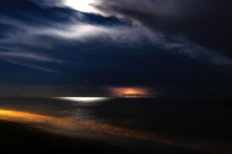 Free Image of Sun Shining Through Clouds Over Ocean 