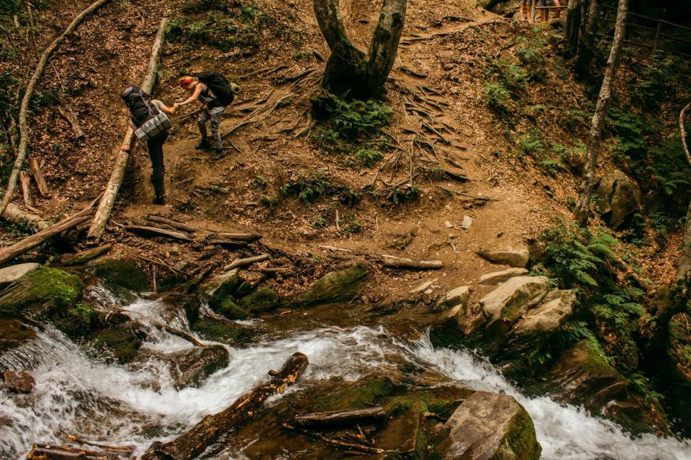 Free Image of Man Climbing Hill Beside River 