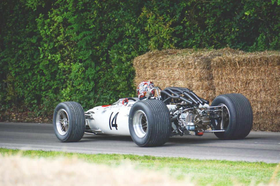 Free Image of Silver Race Car Driving Next to Hay Pile 
