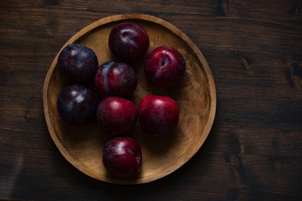 Free Image of Wooden Bowl Filled With Plums on Wooden Table 