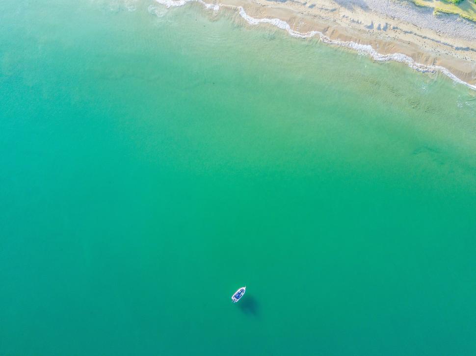 Free Image of Aerial View of a Beach With Boat in Water 