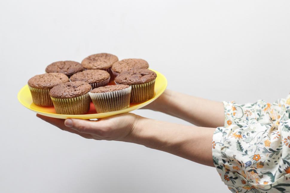Free Image of Person Holding Plate With Cupcakes 