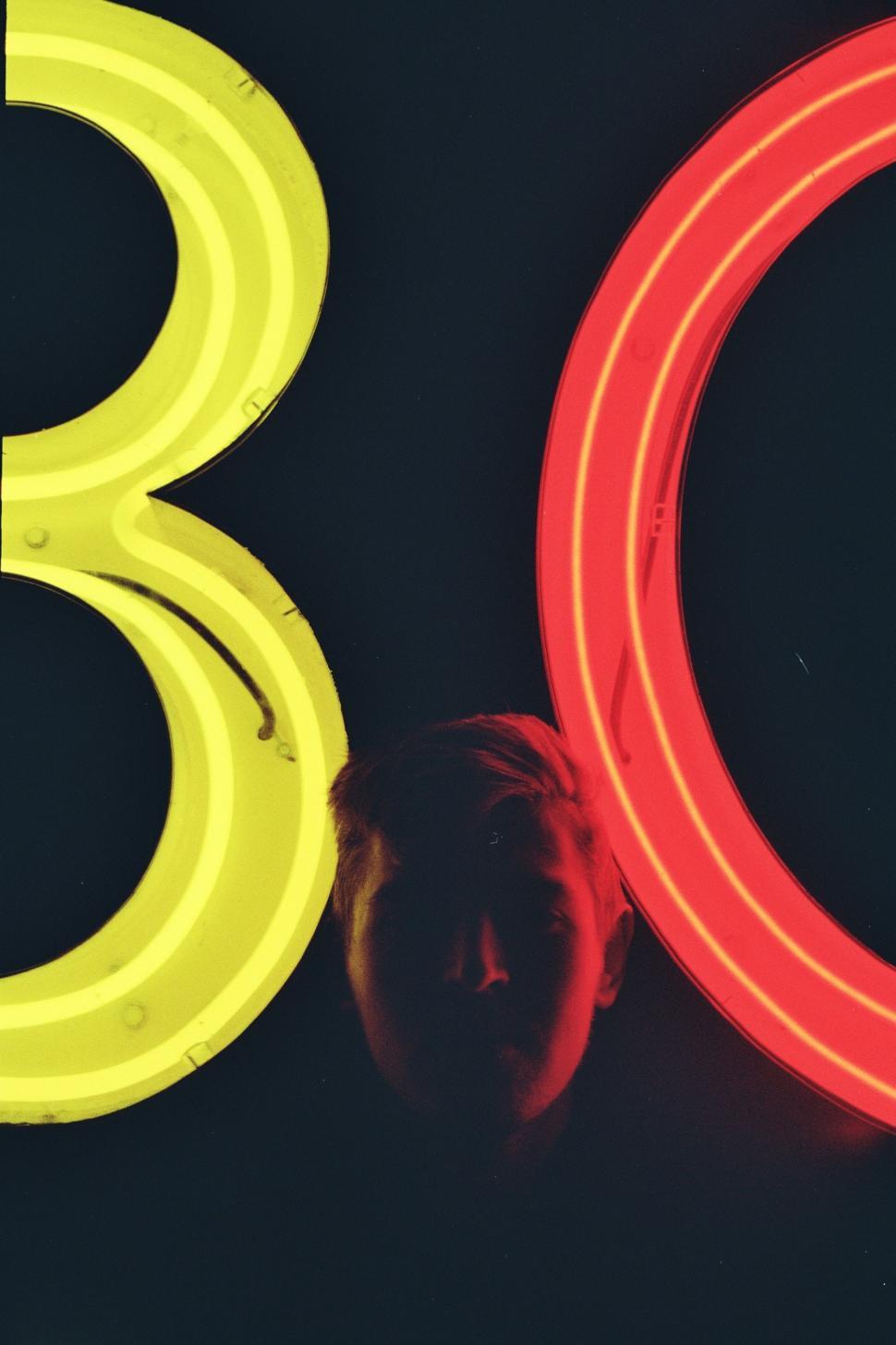 Free Image of Person Standing Next to Neon Sign 