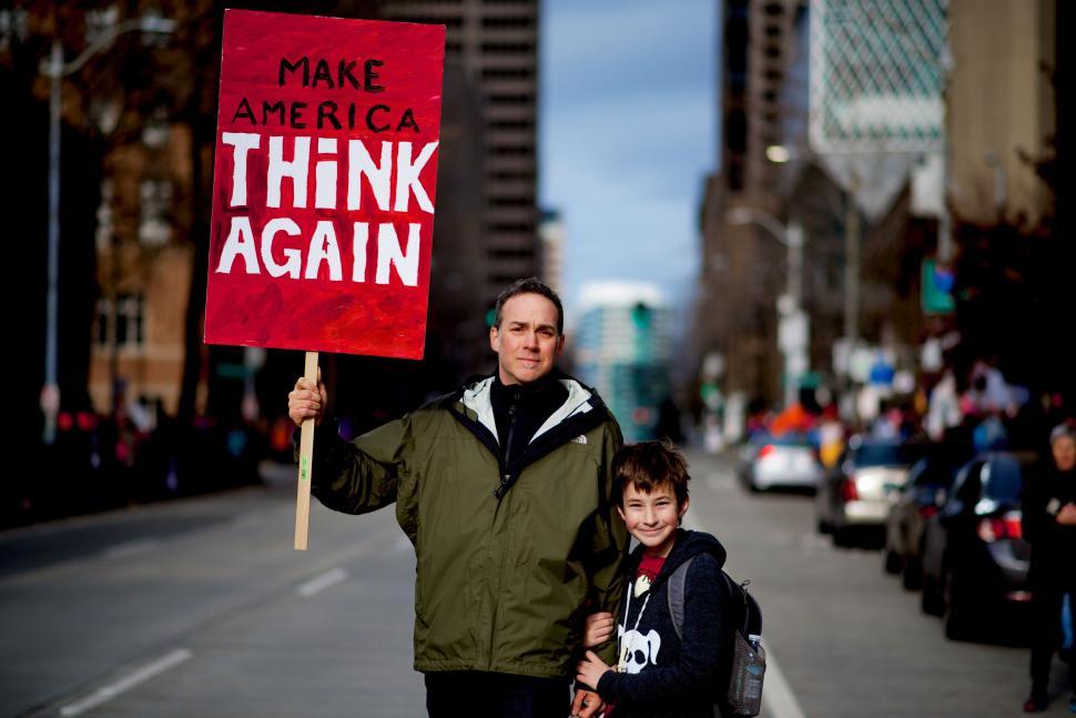 Free Image of Man and Boy Holding Make America Think Again Sign 