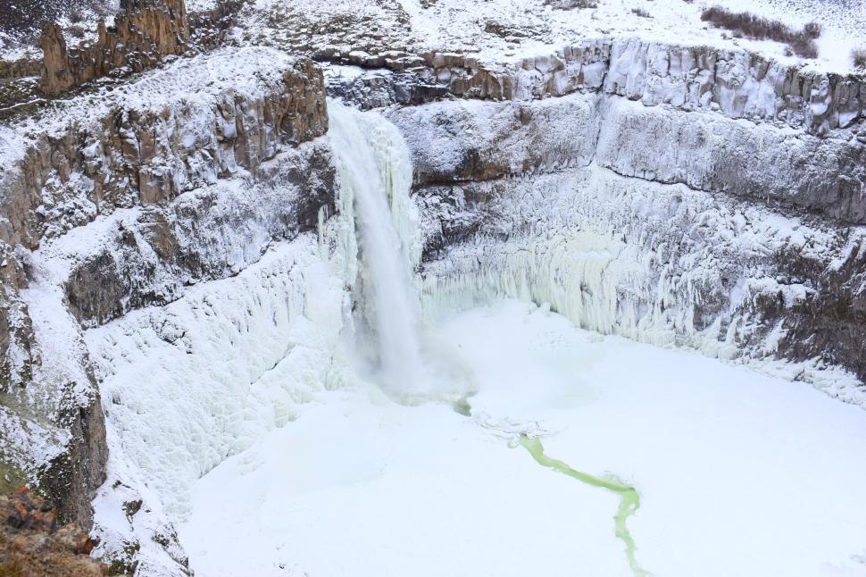 Free Image of Majestic Waterfall With Snow-Covered Ground 