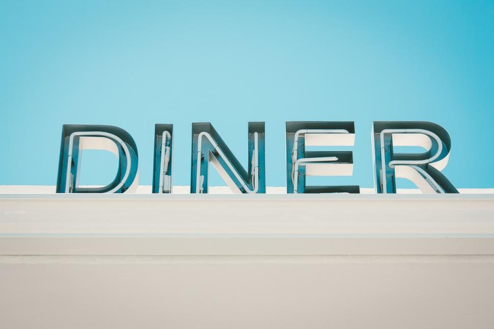 Free Image of Dinner Written in Metal Letters Against a Blue Sky 