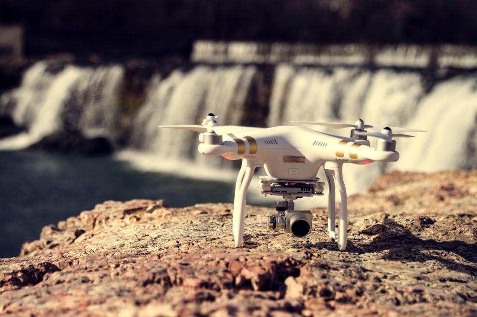 Free Image of White Remote Controlled Flying Over a Waterfall 