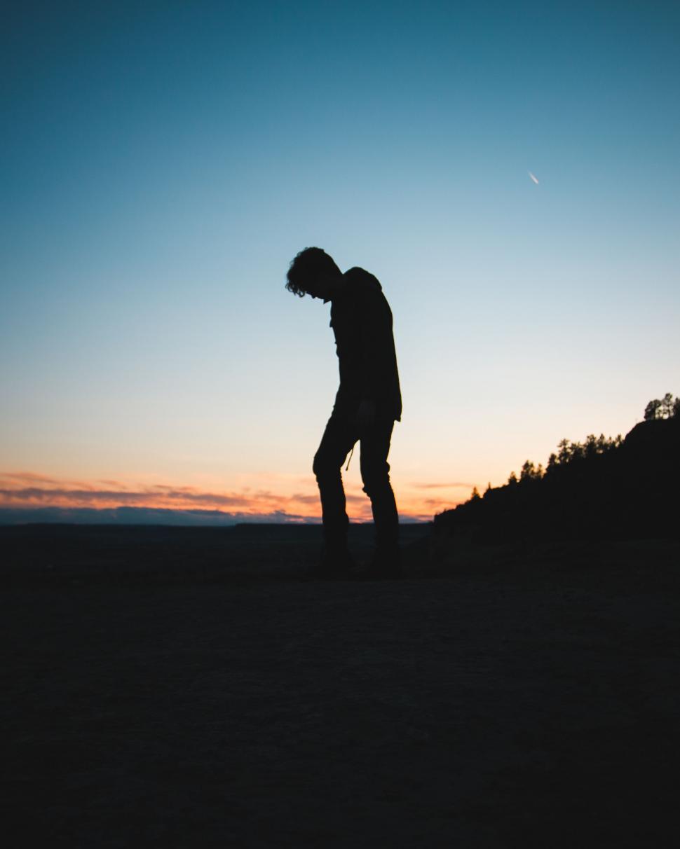 Free Image of Man Standing on Top of Hill at Sunset 