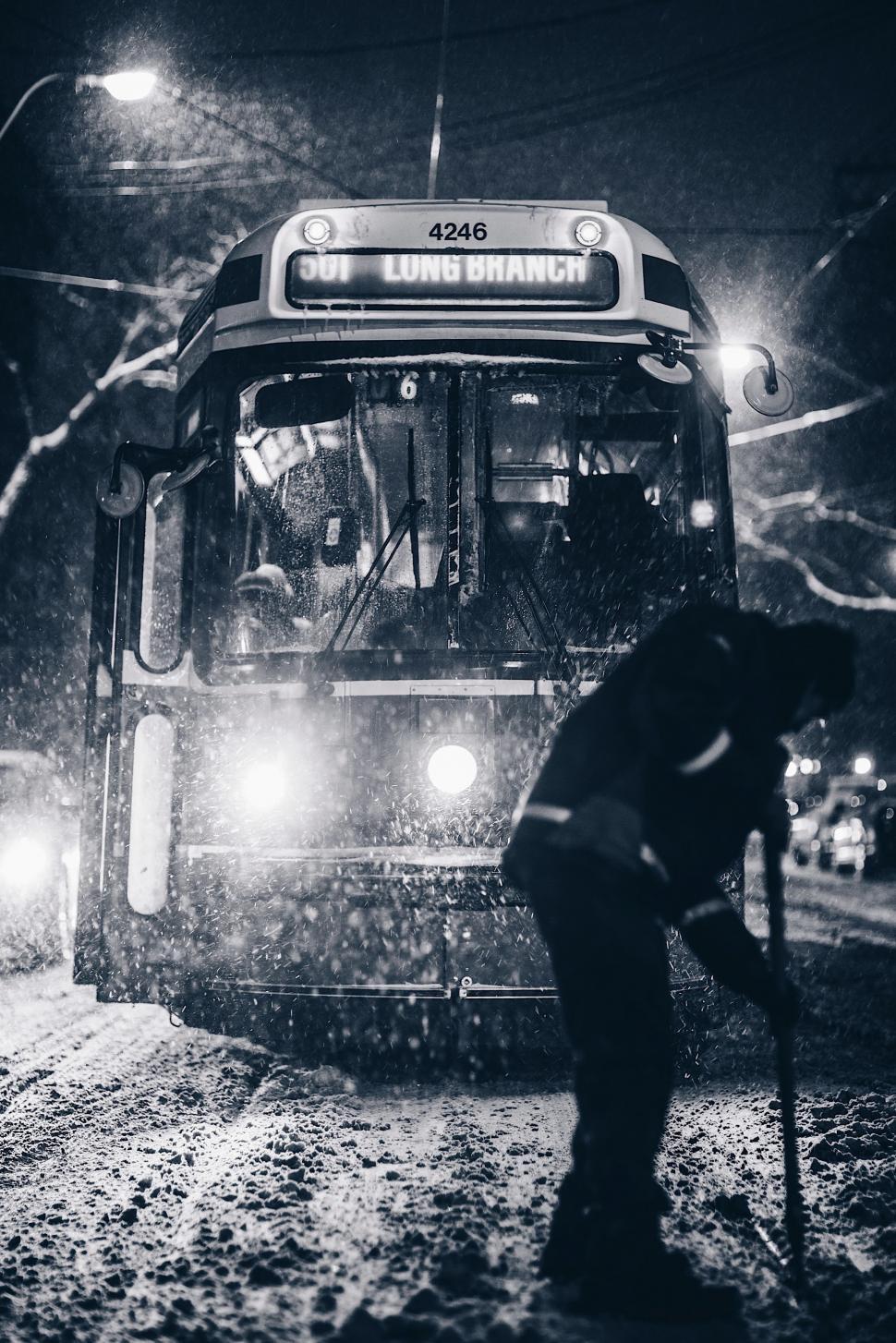 Free Image of Bus Driving Down Snow Covered Street at Night 
