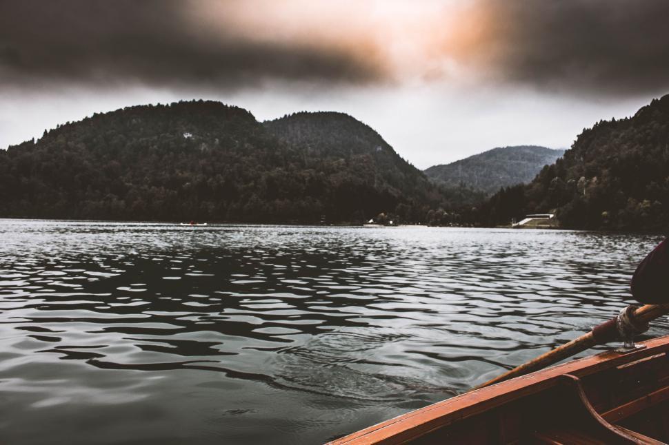 Free Image of Person Paddling Canoe on Lake With Mountains in Background 