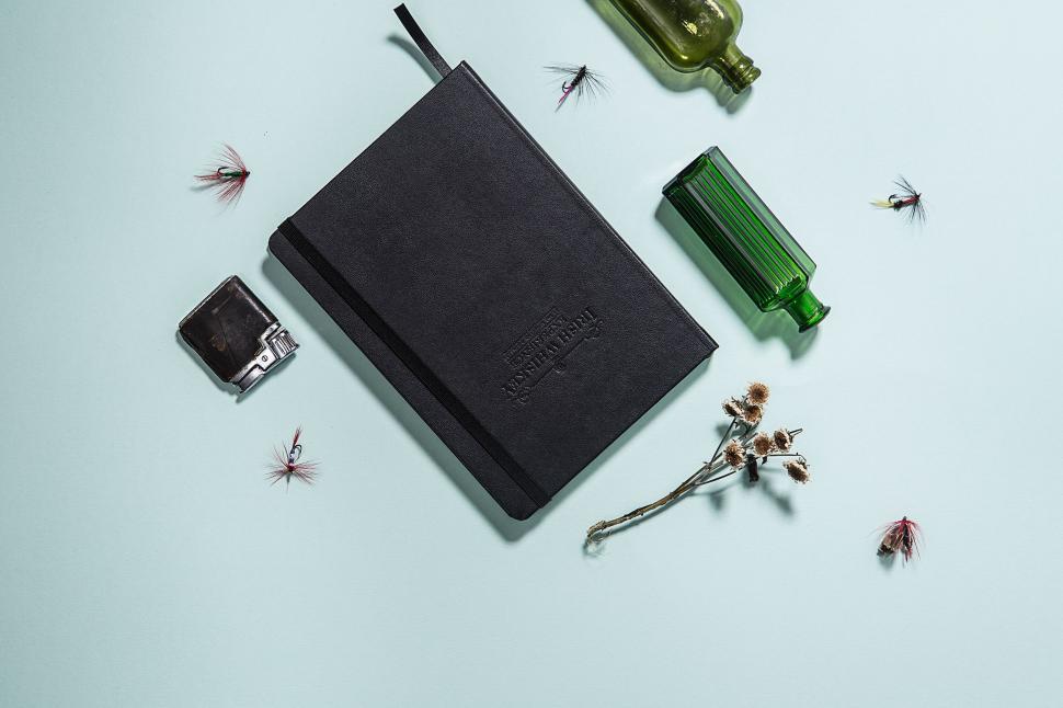 Free Image of Notebook Surrounded by Flies and Bottle of Wine 