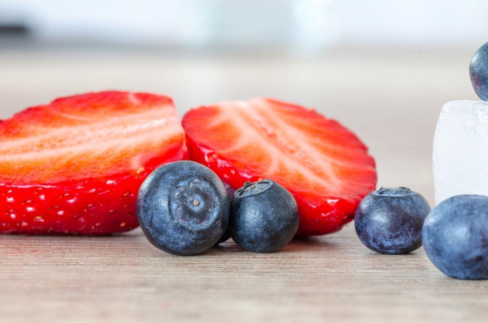 Free Image of Fresh Strawberries, Blueberries, and Ice Cubes on a Table 