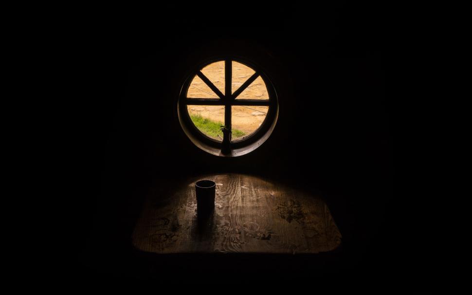 Free Image of Dark Room With Round Window and Cup 