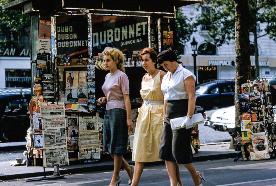 Free Image of Group of Women Walking Past Kiosk 